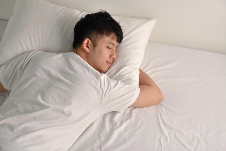 Man sleeping comfortably, demonstrating recommended remedies to reduce snoring and improve breathing during sleep