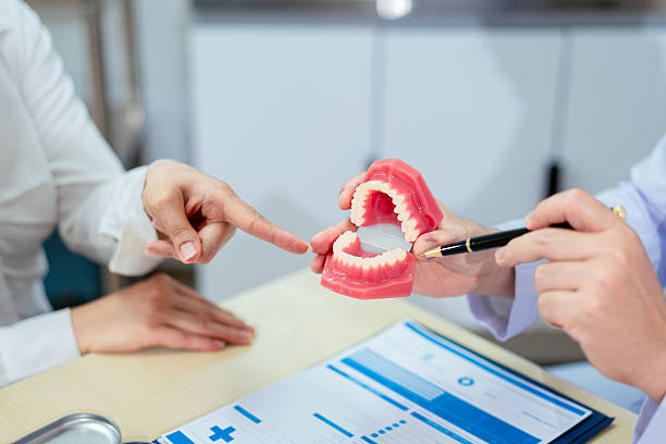 Consultation showing two people discussing a dental model, possibly explaining MARPE treatment options.